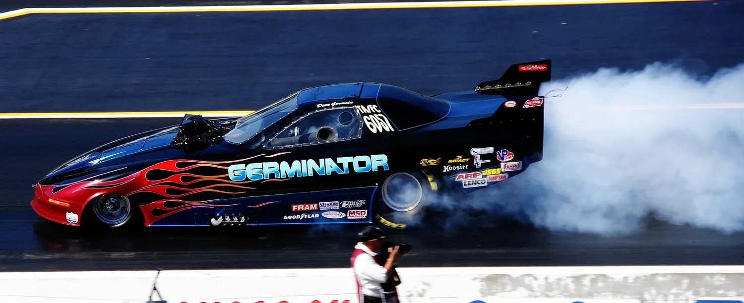 Funny car launching in a burst of flame and tire smoke