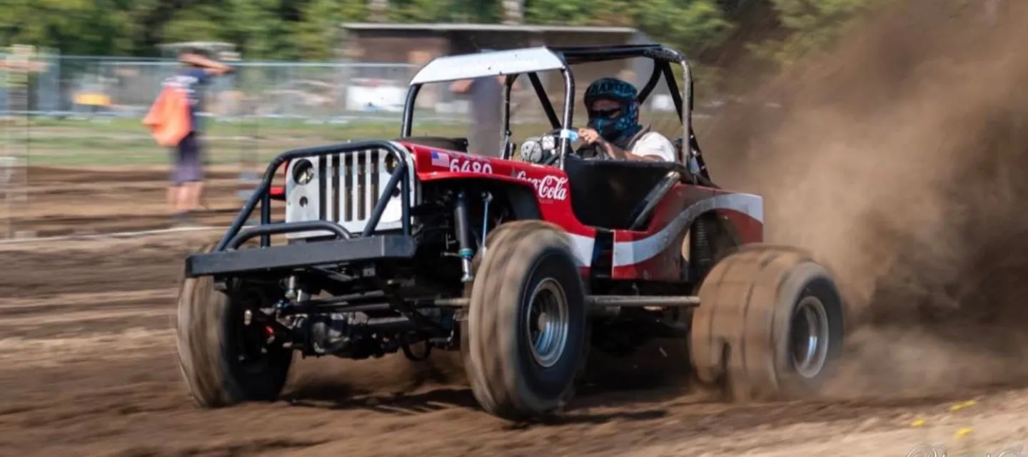 A sand buggy blasting dirt down the mud drag pit